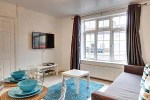 a living room with a couch and a large window at Walter House in Edgware