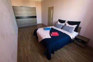 une chambre avec un grand lit avec des draps et des oreillers bleus dans l'établissement Suitu apartments, à Liepāja