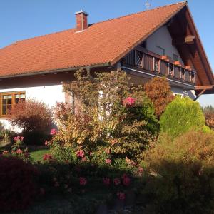 a house with a red roof and some flowers at Ruhige Ferienwohnung in Schollbrunn