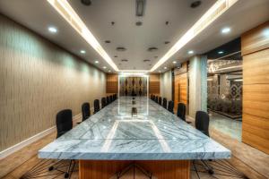 a conference room with a long table and chairs at Raia Hotel Kota Kinabalu in Kota Kinabalu