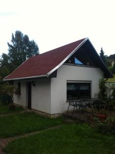 una casa bianca con tetto rosso e tavolo di Ferienhaus Dani a Bad Gottleuba-Berggiesshübel