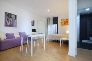 a living room with a purple couch and a table at Apartamentos Centro Cordoba in Córdoba