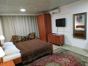a hotel room with a bed and a television at ApartHotel "Ha-Tzomet" in Bat Yam