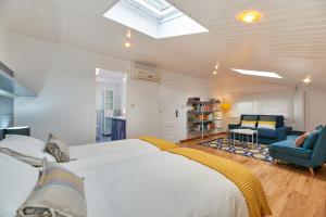 a bedroom with a white bed and a blue chair at Berce in Arzúa