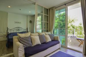 a living room with a couch and a balcony at Summer Hua Hin in Hua Hin