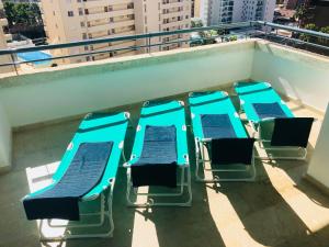 a group of blue chairs sitting on a balcony at Holiday Apartment 5 min to Levante beach in Benidorm