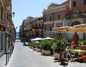 a street with tables and chairs and umbrellas on a city street at Dani's House - affittacamere nel cuore di Cagliari in Cagliari