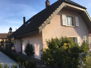 una casa con techo negro y valla en Les Ouches, en Saint-Blaise