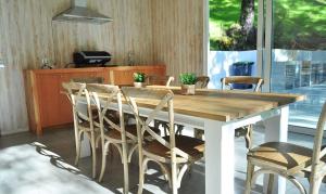 mesa de comedor con sillas y cocina en EDIFICIO ALTA VISTA PUCON, en Pucón