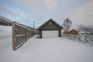 a building with a snow covered driveway next to a fence at Apartment between Ustaoset and Geilo in Geilo