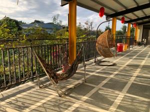 two hammocks sitting on a porch next to a fence at Futian B&B in Jian