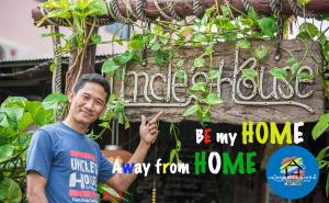a man standing in front of a sign at UNCLE'S HOUSE, Siem Reap in Siem Reap
