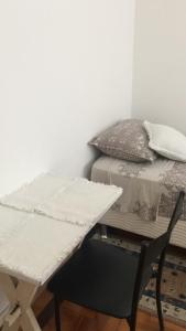 a room with a bed and a table and a chair at Próximo ao Consulado - Quarto Inteiro in Porto Alegre +2 photos