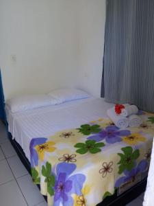 een slaapkamer met een bed met bloemen erop bij Blue House in Fernando de Noronha