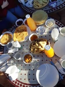 a table with breakfast foods and drinks on it at Dar Sihamou in Tabant