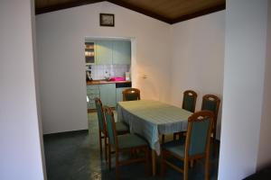 a kitchen and dining room with a table and chairs at Rab Apartment LUCE in Barbat na Rabu