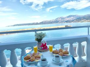 a table with food on a balcony with a view of the water at The Blue Apartments in Hersonissos