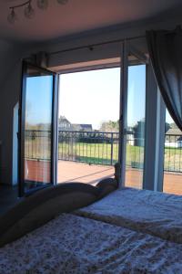 Un dormitorio con una cama y una gran ventana de cristal. en Ferienhaus Harmonia, en Neuendorf Heide