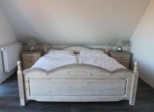 een slaapkamer met een wit bed en 2 nachtkastjes bij Ferienhaus Harmonia in Neuendorf Heide