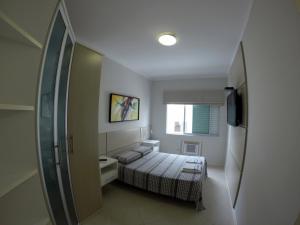 Habitación pequeña con cama y ventana en Apartamento Canasvieiras, en Florianópolis