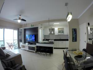 sala de estar y cocina con sofá y mesa en Apartamento Canasvieiras en Florianópolis