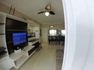 sala de estar con TV de pantalla plana y comedor en Apartamento Canasvieiras, en Florianópolis