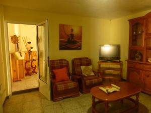 een woonkamer met 2 stoelen en een televisie bij Casa Paco in La Galera