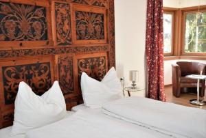 a bedroom with a bed with white sheets and pillows at Sterzingerhof in Vipiteno