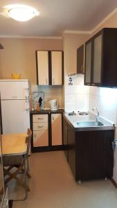 a small kitchen with a sink and a refrigerator at Blue Bay Sea View in Pomorie