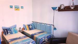 a bedroom with two beds and a lamp and a couch at Blue Bay Sea View in Pomorie +12 photos