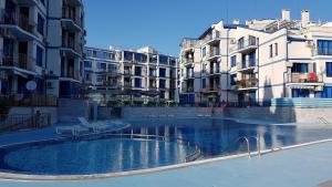 a swimming pool in the middle of some buildings at Blue Bay Sea View in Pomorie