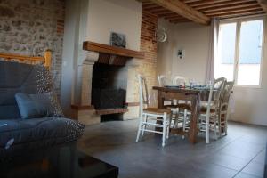 a living room with a table and chairs and a fireplace at La SuccuRSalle in Honfleur