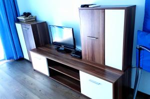 a wooden entertainment center with a television on top of it at Blue Bay Sea View in Pomorie