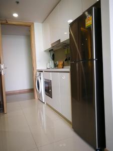 a kitchen with a refrigerator and a washer and dryer at The Riviera Wongamat Hong Apartment in Pattaya North