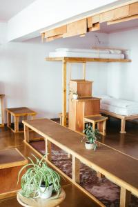 Hostel & Garten Eden في لايبزيغ: غرفة بها طاولات وسرير بطابقين ونباتات الفخار