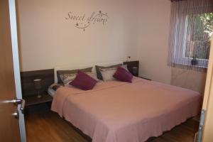 a bedroom with a large bed with purple pillows at Melios in Balingen