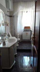 a bathroom with a sink and a toilet and a window at Il Frutteto in Assergi