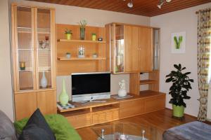 a living room with a television on a wooden entertainment center at Ferienwohnung Helmberger in Burgkirchen in Burgkirchen an der Alz