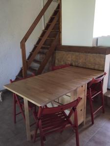una mesa de madera con 2 sillas y una escalera en Chouetterie en Saint-Dizier-Leyrenne
