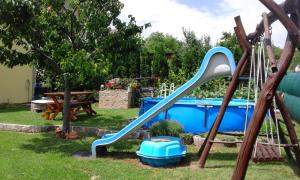 a playground with a blue slide in a yard at Papp Apartman Felsőörs in Felsőörs