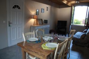 a dining room table and chairs with a wooden table and plates and glasses at La SuccuRSalle in Honfleur