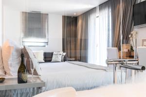 サントロペにあるHotel le Mandalaのベッドとソファ付きのホテルルーム