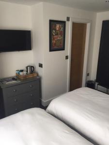 a hotel room with two beds and a flat screen tv at Carlton Hotel in Ilfracombe