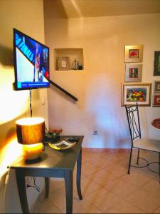 un soggiorno con tavolo, TV e sedia di Holiday Home Little Heaven a Slatine