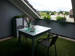a table and two chairs on a balcony with plants at Boave ut Wirkes in Klimmen