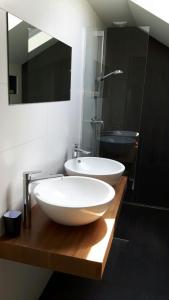 a bathroom with two white sinks and a mirror at Boave ut Wirkes in Klimmen