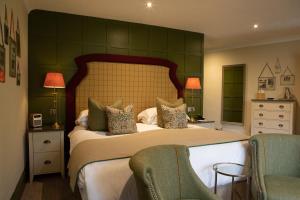 a bedroom with a large bed with two chairs at Rothay Manor Hotel in Ambleside