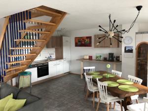eine Küche und ein Esszimmer mit einem Tisch und einer Treppe in der Unterkunft Ferienhaus am Kaiserstuhl in Endingen