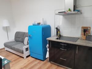 コトブスにある2 Raum Gartenwohnung am Spreewaldradweg in Cottbusのキッチン(ソファの横に青い冷蔵庫付)