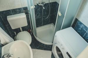 a bathroom with a toilet and a washing machine at Apartmani Marko in Makarska +32 photos